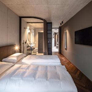 1 Schlafzimmer mit 2 Betten und einem TV an der Wand in der Unterkunft Lifestyle B&B by Phillip Sigwart in Brixlegg