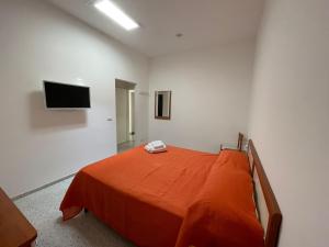una camera con un letto e una coperta arancione di La Musa a Capri