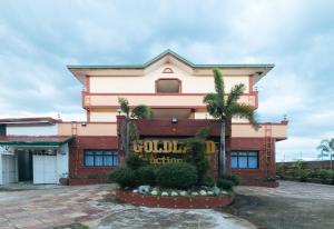 um edifício com um letreiro vendido à frente em RedDoorz @ Goldland Spring Resort Urdaneta City em Urdaneta