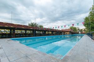 a large swimming pool in a building with flags at RedDoorz @ Goldland Spring Resort Urdaneta City in Urdaneta