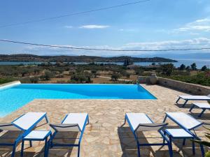 a group of chairs and a swimming pool at Casa Marimar Boutique Bungalows & Suites in Porto Heli