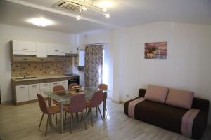 eine Küche und ein Wohnzimmer mit einem Tisch und einem Sofa in der Unterkunft Ansamblul rezidential Phoenix in Orăştie
