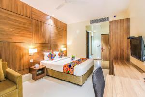 a hotel room with a bed and a couch at FabHotel RK International in Mumbai