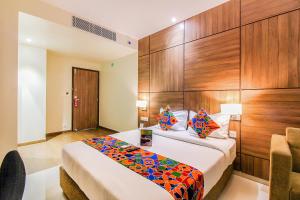 a bedroom with a bed with a wooden wall at FabHotel RK International in Mumbai