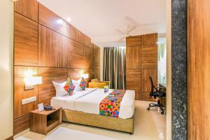 a hotel room with a bed and a desk at FabHotel RK International in Mumbai