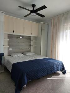 a bedroom with a bed with a ceiling fan at Casita Amigo in Moraira