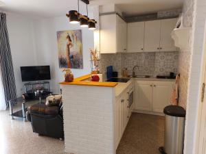 a kitchen with white cabinets and a counter with a sink at Casita Amigo in Moraira