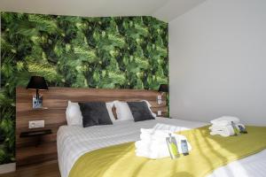 - une chambre avec un lit et du papier peint vert dans l'établissement ATHOME RESIDENCE ET SPA, à La Rochelle