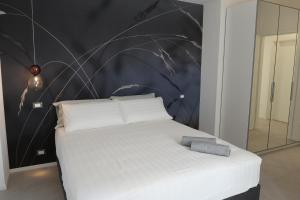 - un lit blanc dans une chambre avec un mur dans l'établissement Residence TRE LEONI, à Caorle