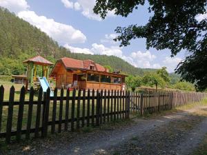 een houten huis met een hek ervoor bij Drinski dragulj in Višegrad