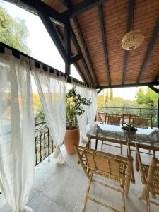 un patio con tavolo e sedie sul balcone. di Eleni's Guesthouse a Paleokastritsa