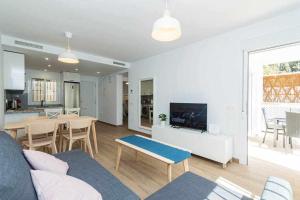 ein Wohnzimmer mit einem Sofa und einem Tisch mit einem TV in der Unterkunft Casablanca 4 Apartamento con jardín privado in Fuengirola