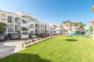 ein großes Gebäude mit Autos auf einem Parkplatz in der Unterkunft Casablanca 4 Apartamento con jardín privado in Fuengirola