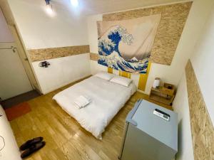 um pequeno quarto com uma cama e um quadro na parede em 逢甲旅人Inn em Taichung