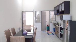 Il comprend une cuisine et une salle à manger avec une table et un réfrigérateur. dans l'établissement VUE RESIDENCES SERVICE SUITE 8 Pax, à Kuala Lumpur