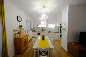 佩奇的住宿－PéterPál apartman，白色的厨房配有黄色的桌子和椅子