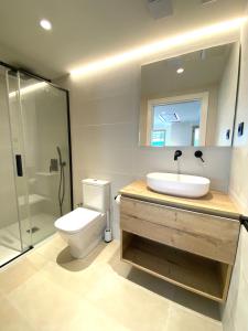 a bathroom with a toilet and a sink and a shower at Acacias Suites Apartments Salou in Salou
