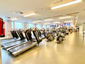 un gimnasio con una fila de cintas de correr y máquinas en Tammer Huoneistot - City Suite 3 - Public Sauna, Gym & Pool en Tampere