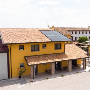 Agriturismo Tiare dal Gorc في Gorgo: منزل أصفر على السطح مع ألواح شمسية