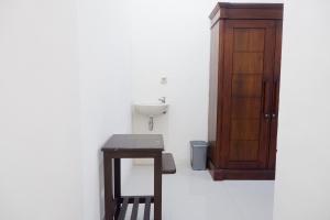 baño con lavabo y mesa de madera en Reddoorz at Bale Eja Syariah Senggigi en Montongbuwoh