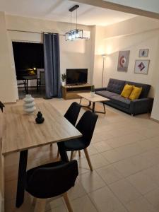 ein Wohnzimmer mit einem Tisch und einem Sofa in der Unterkunft Urban City Apartments in Xylokastro