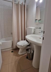 ein Badezimmer mit einem weißen WC und einem Waschbecken in der Unterkunft Urban City Apartments in Xylokastro