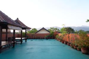 a patio with benches and potted plants on it at Reddoorz at Bale Eja Syariah Senggigi in Montongbuwoh