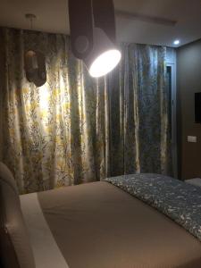 拉巴特的住宿－Agréable appartement，一间卧室配有一张带窗帘和灯的床