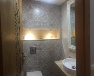 Un baño con lavabo, inodoro y espejo. en Aryam Room, en Rabat 15 fotos más