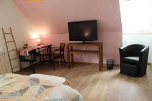 a living room with a television and a table with chairs at ROC callac in Saint-Gilles-du-Vieux-Marché