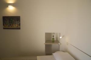 a white room with a bed and a picture of cactus at Terrazza Grecale in Rodi Garganico