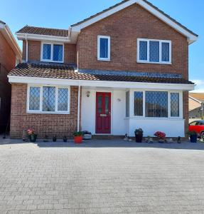 a brick house with a red door at Private Guest Suite in Telscombe