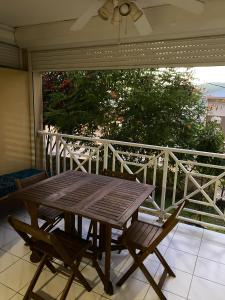 een houten tafel en 2 stoelen op een balkon bij Studio avec vue sur la mer piscine partagee et terrasse amenagee a Le Marin a 3 km de la plage in Le Marin