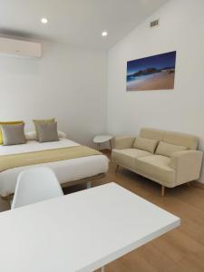 sala de estar con 2 camas y sofá en Píllaras da Lanzada, en A Lanzada