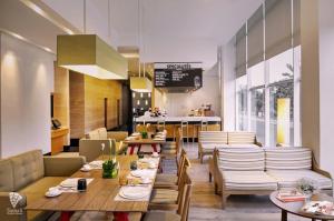 a restaurant with tables and chairs and a counter at d'primahotel Tangerang in Tangerang