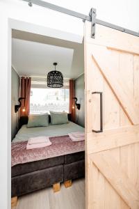 ザントフォールトにあるAmsterdam Beach Apartment 52のベッドルーム1室(大型ベッド1台、木製のドア付)