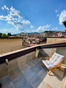 een stoel op een balkon met uitzicht op de stad bij Magic Place Bergamo! Appartamento Relax con terrazza nel cuore di Bergamo in Bergamo
