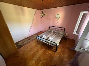 1 dormitorio con 1 cama en una habitación con suelo de madera en Kod Škilje, en Šibenik