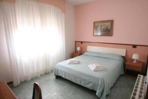 een slaapkamer met een bed met twee handdoeken erop bij Hotel Redi in Montecatini Terme