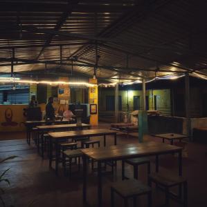 um grupo de mesas e cadeiras numa sala com luzes em MID BEACH STAY Gokarna em Gokarna