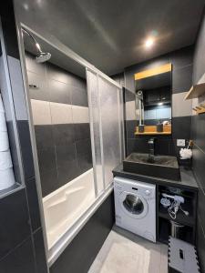 une petite salle de bains avec un lave-linge et un lavabo dans l'établissement Appt 123 Home Club Tignes, à Tignes