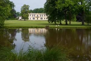 a large house with a pond in front of it at Les Sources de Caudalie in Martillac