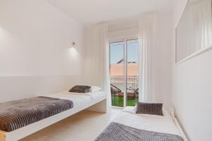 Una habitación blanca con dos camas y una ventana. en Elite Luxury Sunset, en Puerto de Santiago 37 fotos más