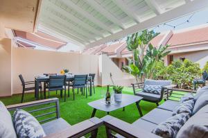 een patio met een tafel en stoelen bij Elite Luxury Sunset in Puerto de Santiago