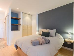 a bedroom with a large bed with a gray wall at Marsin Canteras in Las Palmas de Gran Canaria