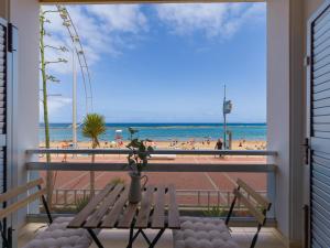 a balcony with two chairs and a view of the beach at Marsin Canteras in Las Palmas de Gran Canaria