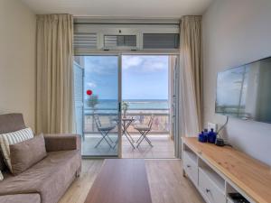 een woonkamer met een bank en uitzicht op de oceaan bij Marsin Canteras in Las Palmas de Gran Canaria