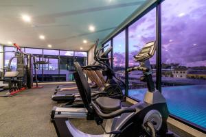 a gym with cardio machines and a swimming pool at Wekata Luxury in Kata Beach