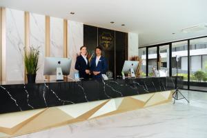 two women standing at a counter in a lobby at Wekata Luxury in Kata Beach