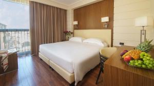 una habitación de hotel con una cama y una mesa con un bol de fruta en Hotel Villa Zoia, en Boltiere
